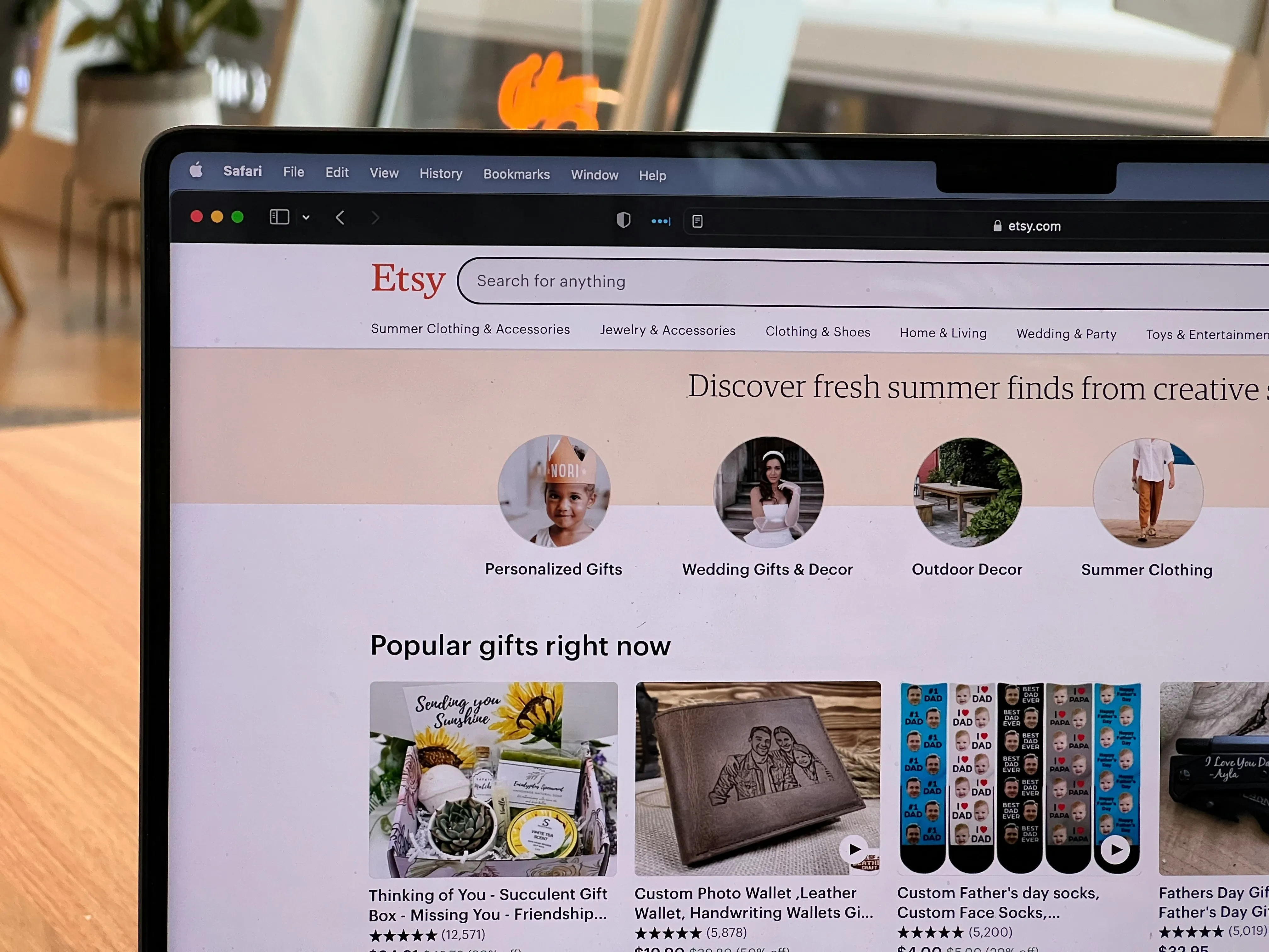 Laptop screen showing the Etsy homepage with category tiles for Personalized Gifts, Wedding, Outdoor Decor, and Summer Clothing
